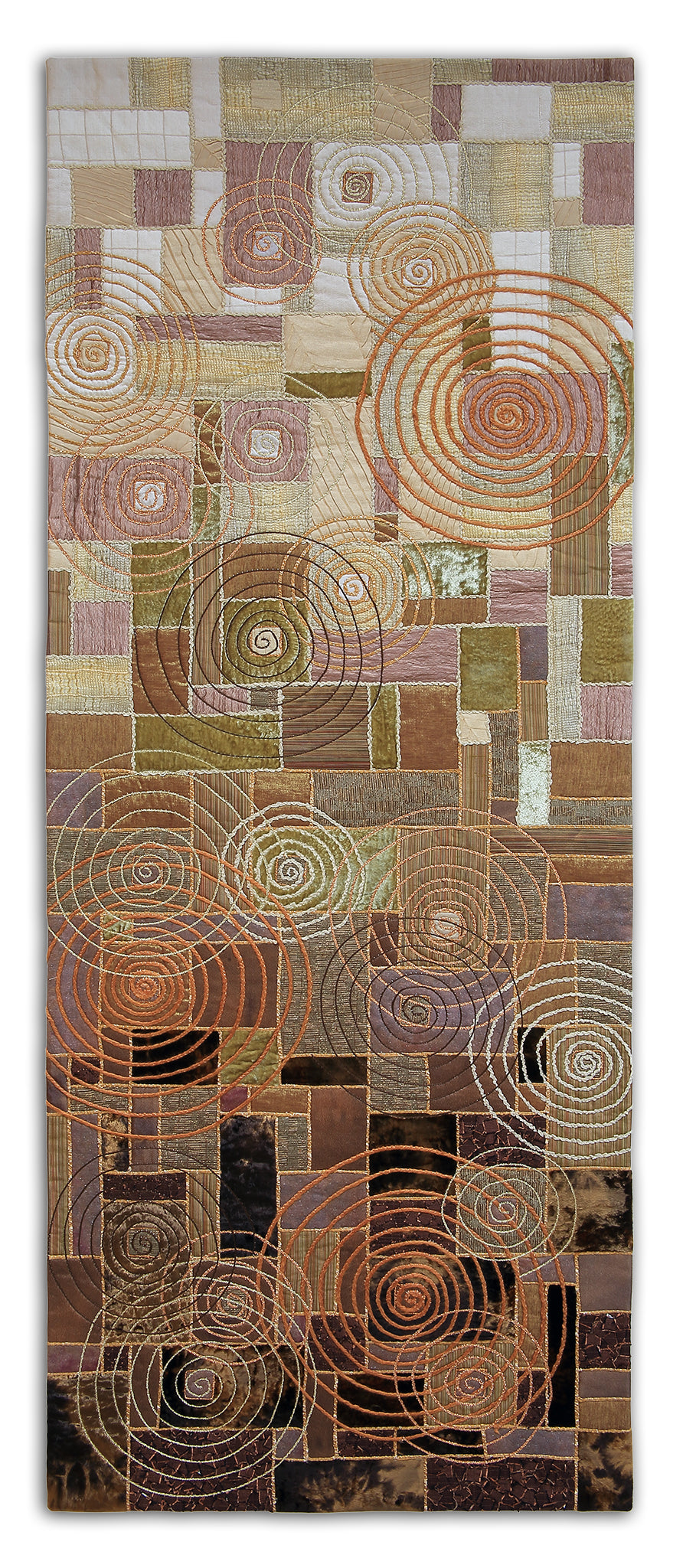 ART QUILT TITLED: Spiraling CREATED: by Karen Hampton SIZE: 9 ¼” x 50”  The original design has no machine piecing. Each piece of decorator fabric was fused to a muslin backing and yarns were couched over the edges. The spiraling rings were added with additional yarn couching